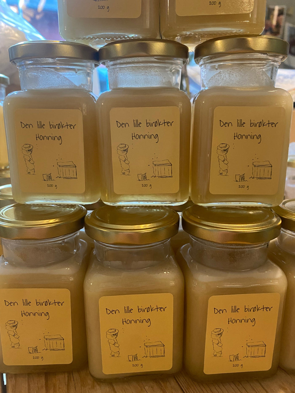 Stabler av honningglass med lys gul etikett